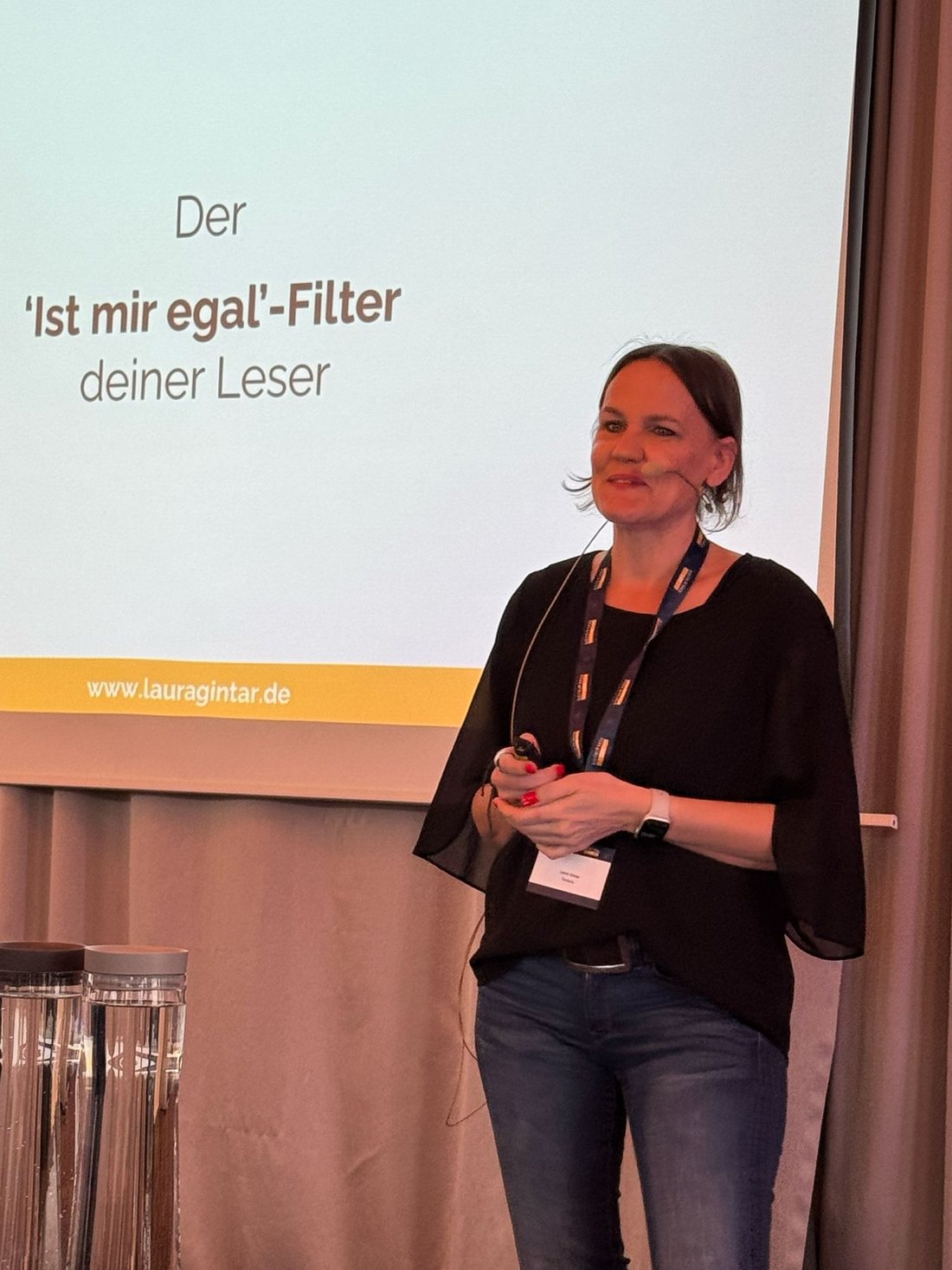 Laura Gintar auf der B&uuml;hne, im Hintergrund ihre Folie zum Ist-mir-egal-Filter
