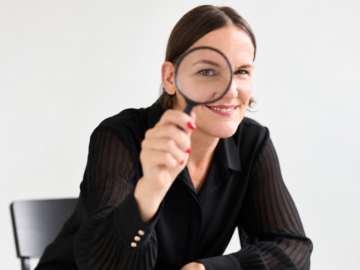 Laura Gintar schaut durch eine Lupe